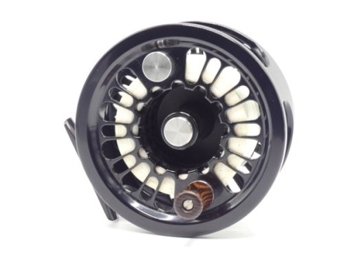 A good Abel Super 12W saltwater/salmon fly reel and spare spool, black anodised left hand wind model with skeletal drum and backplate, counter-balanced rosewood handle, block foot and rear spindle mounted tension adjuster, only very light use, in origina