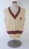 Ian Botham. Somerset Ist XI sleeveless sweater issued to and worn by Botham in his early playing career. The cream woollen sweater by ‘Morrant Sports’ with county colours of maroon, grey and black to neck and waist and emblem of maroon dragon and red tong