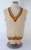 Ian Botham. England 1980s. Original M.C.C. touring sleeveless woollen sweater worn by Botham during his playing career. The sweater with M.C.C. colours to neck and waist. ‘Ian Botham’ cloth name tag to inside collar. Maker unknown. Minor stain to front, t