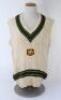 Merv Hughes. Victoria & Australia 1981-1995. Original Australia woollen sleeveless sweater worn by Hughes during his playing career, probably late 1980s. The sweater with Australia colours of green and gold to neck and waist, Australia shield emblem to ch