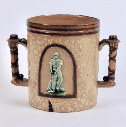 Doulton Lambeth large stoneware two handled loving cup, in brown, impressed with a delicate white flower and floral decoration, with two moulded relief vignettes in roundels of a batsman playing a shot and a fielder or bowler holding the ball in green on 