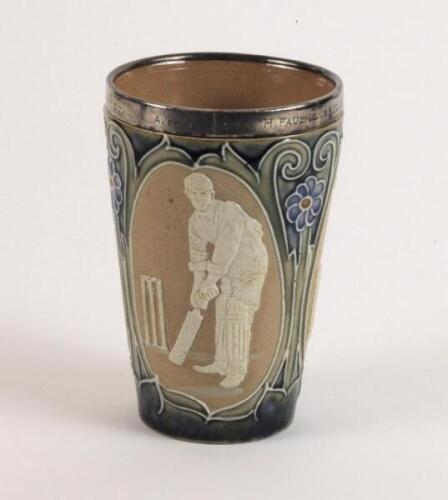 Doulton Lambeth stoneware beaker, moulded with relief vignettes of cricketers, a batsman, bowler and wicket keeper, Abel, Woods and McGregor in white on a brown background. With stylised daisy and floral leaf Art Nouveau decoration to top and sides in gre