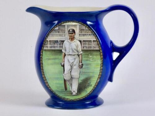 John Berry ‘Jack’ Hobbs. Surrey & England 1905-1934. New Hall Pottery blue water jug, printed with an oval colour portrait of Hobbs walking out to bat with stands to background, printed signature below. Crossed bats, stumps and cricket balls on crest to v