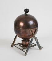 Cricket themed egg coddler. An epns [?] circular cricket ball shaped domed egg coddler with finial to top, supported on crossed cricket bat and stump legs with burner beneath. Approximately 7.75” tall. Unusual. Some loss to the base of the finial, slight 