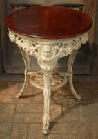 W.G. Grace. Original cast iron circular public house table with circular wooden top, supported by three legs, moulded with portrait busts of Grace wearing cricket cap to top of each leg with imprinted initials ‘W.G’ above, and decorated pierced apron of b