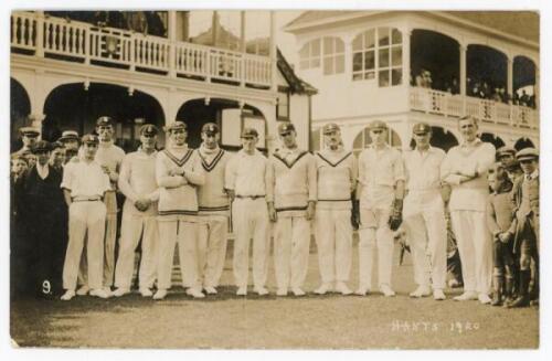 ‘Hants 1920’. Sepia real photograph postcard of the Hampshire team standing in one row wearing cricket attire on the field with the pavilion and spectators in the background, assumed to be at Bournemout. Players names annotated in pencil to verso includin