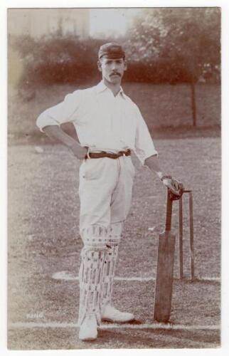 John Herbert King. Leicestershire & England 1895-1925. Sepia real photograph photograph of King standing full length at the wicket wearing cricket attire and County cap, leaning on his bat. Blind embossed stamp to lower right corner for Foster of Brighton