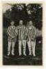 ‘Denton Bros.’. Northamptonshire. Excellent mono real photograph postcard of the three Denton brothers, William, Arthur and John, standing full length wearing cricket attire and matching striped blazers, with arms linked. Undated but probably c.1920. Phot