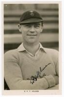 Errol Reginald Thorold Holmes. Surrey, Oxford University & England 1924-1955. Mono real photograph postcard of Holmes, head and shoulders, wearing cricket attire and Surrey cap. Printed name to lower margin. Very nicely signed in black ink to the photogra