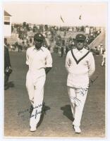 M.C.C. Australian Touring Team v C.I. Thornton’s XI, Scarborough 1928. Original mono photograph of K.S. Duleepsinhji (Sussex) and Wilfred Rhodes (Yorkshire) walking side by side on the outfield at Scarborough with crowds in the stands, for the match playe