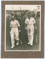 M.C.C. Australian Touring Team v C.I. Thornton’s XI, Scarborough 1928. Original mono photograph of Ernest Tyldesley (Lancashire) and Maurice Tate (Sussex) walking walking out to bat for M.C.C. at Scarborough with crowds in the stands in the background, fo