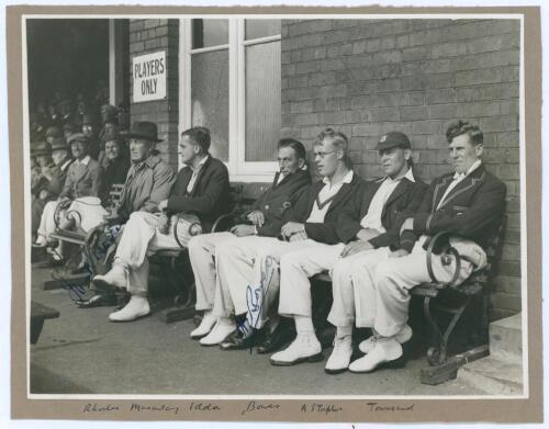 Bill Bowes and Wilfred Rhodes. Yorkshire. Original mono photograph of six players seated on a bench watching play in progress outside the players’ dressing room of a pavilion with spectators seated in the background. Nicely signed in ink to the photograph