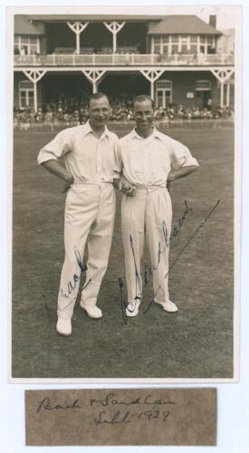 ‘Peach & Sandham’ 1929. Original sepia real photograph plain back postcard of Alan Peach and Andy Sandham standing side by side on the outfield wearing cricket attire at Scarborough with the pavilion in the background. Both players appeared for Lord Hawke