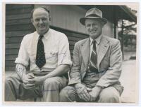 William Joseph ‘Bill’ O’Reilly. New South Wales & Australia 1927-1946 and Clarence ‘Clarrie’ Victor Grimmett. Victoria, South Australia & Australia 1918-1941. Excellent informal mono press photograph of the two Australian Test players sitting in front of 