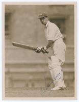 Andrew Sandham. Surrey & England 1911-1937. Original sepia press photograph of Sandham in batting action wearing his England cap. Very nicely signed in blue ink to the photograph by Sandham. Official stamp for Central Press Photos to verso. 6.5”x8.5”. Ver