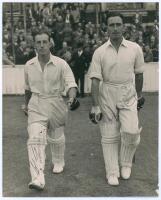 Middlesex C.C.C. 1947. Denis Compton and Bill Edrich. Large original mono press photograph of Compton and Edrich walking out to bat in 1947. Signed in ink to the photograph by both players. Central Press Photos, London. 8&rdquo;x10&rdquo;. Small wear to lower right c