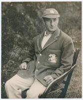 Alfred Percy &lsquo;Tich&rsquo; Freeman. Kent & England 1914-1936. Large original mono photograph of Freeman three quarter length wearing M.C.C. tour cap and blazer, seated in a garden chair. The photograph by B. & W. Fisk-Moore of Canterbury, laid to tightly trimmed