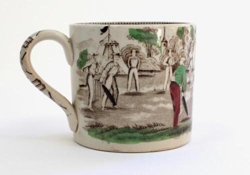 Village cricket mug. Staffordshire 19th century mug, transfer printed in black with two scenes of village cricket, with church and tents to background, floral and oak leaf rim decoration and crossed cricket bats, balls and stumps decoration to handle. Han