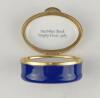 &lsquo;NatWest Bank Trophy Final 1983&rsquo;. Halcyon Days oval enamelled pill box. The lid with scene of the NatWest Tower, the hinged lid revealing title &lsquo;NatWest Bank Trophy Final 1983&rsquo;&rsquo;. The outer decorated in cobalt blue Stamped to base &lsquo;Bilston & Battersea Enam - 2