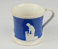 Staffordshire blue ground waisted cricket mug with strap handle and beaded rim. With three relief moulded figures of a batsman, bowler and wicket keeper in cream, believed to be Lillywhite, Pilch and Box. c1860. Very minor wear to rim, minor wear to base 