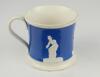 Staffordshire blue ground waisted cricket mug with strap handle and beaded rim. With three relief moulded figures of a batsman, bowler and wicket keeper in cream, believed to be Lillywhite, Pilch and Box. c1860. Very minor wear to rim, minor wear to base - 3