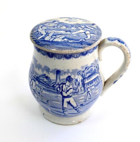 Staffordshire shaving mug. Victorian Staffordshire shaving mug and ceramic cover (lid) with strap handle, transfer printed in blue, with a cricket scene of batsman, wicket-keeper and two fielders with pavilion and trees to background. To verso, a football