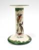 &lsquo;The Boss&rsquo; A very rare Royal Doulton &lsquo;All Black Team&rsquo; series candlestick, entitled &lsquo;The Boss&rsquo;, printed and painted with a boy cricketer in red shirt, wearing an unpire&rsquo;s coat and a floppy hat holding a cricket bat to side Green floral decoration above and