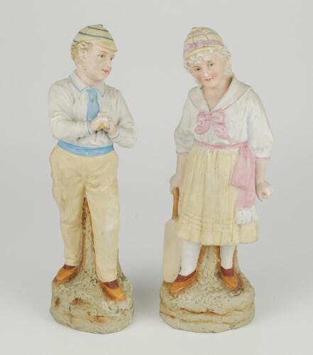 &lsquo;Young England and Young England&rsquo;s sister&rsquo;. A pair of continental bisque figures of a boy, wearing hooped cap holding a cricket ball and a young girl, also wearing a hooped cap, dressed in three-quarter dress holding a cricket bat, both on naturalistic ba