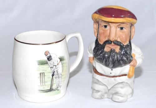 W.G. Grace. Sandland ceramic tankard with transfer printed colour image of Grace in batting pose and and &lsquo;Old Father Time&rsquo; to reverse. Gilt lustre to rim and handle. 4&rdquo; tall. Sold with a Manor potteries china caricature toby jug of Grace in M.C.C. cap. Ap