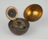 Cricket ball inkwell. Leather cricket ball ink well, well made with seam and stitched quarters. The ball is split and hinged and opens to reveal a brass liner with an original glass ink well. Approximately 2.5” circumference. Some wear to ball otherwise i