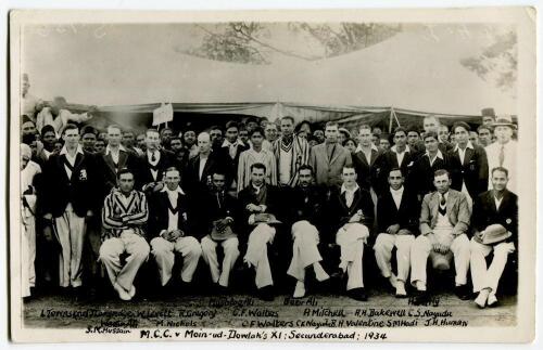 M.C.C. tour of India & Ceylon 1933/34. Real photograph mono joint team postcard of the M.C.C. and Dowlah XI teams and spectators standing and seated on the field in front of a marquee at the Gymkhana Ground, Secunderabad . Handwritten title and players na