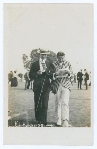 Kenneth Lotherington Hutchings. Kent & England 1902-1912. Unusual early mono real photograph postcard of Hutchings, wearing cricket attire and striped blazer, walking on the outfield while studying a newspaper/ magazine beside a smartly dressed young gent