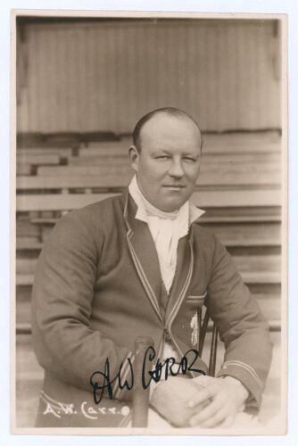 Arthur William Carr. Nottinghamshire & England 1910-1934. Early sepia real photograph postcard of Carr seated half length on pavilion steps, wearing cricket attire and M.C.C. touring blazer. C.H. Richards of Nottingham. Very nicely signed in black ink to 