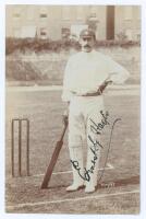 Ernest George ‘Ernie’ Hayes. Surrey, Leicestershire & England 1896-1926. Sepia real photograph postcard of Hayes standing full length at the wicket wearing cricket attire and Surrey cap, leaning on his bat. Very nicely signed in black ink to image by Haye