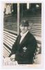 Laurence Barnard &lsquo;Laurie&rsquo; Fishlock. Surrey & England 1931-1952. Original mono real photograph postcard of Fishlock seated half length in front of the pavilion at The Oval, wearing Surrey cap and blazer. Signed in blue ink to the lower left corner by Fishl
