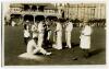 Gentlemen v Players, Scarborough 1931. Sepia real photograph postcard of the tea interval in the match played in September 1931 showing the players being served on the pitch with tea by a waiter and waitress, players stood having a cigarette. George Hirst