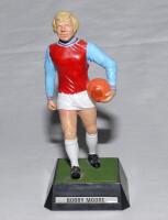 Bobby Moore. West Ham & England. Plastic figurine of Moore in West Ham colours with orange ball in his left hand, on named plinth. ‘Wembley Soccer Stars’ from the series of six figures by Mettoy issued 1972. G/VG.