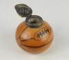 Football inkwell. A Victorian glazed transfer-printed stoneware inkwell, shaped as a slightly deflated football, with plated metal mount and hinged cover formed as a sporting cap, Reg no. 167873 (for 1891) to the underside. Approx 2.75&rdquo; tall. Minor wear, - 2