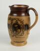 W.G. Grace. Impressive Doulton Lambeth stoneware jug with pale body and dark brown rim, decorated with three portraits/roundels of W.G. Grace, K.S. Ranjitsinhji and George Giffen within scrolling foliage. Two tone brown strap handle. Produced in 1896. App - 2