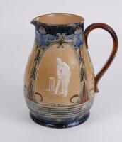 Doulton Lambeth stoneware jug, of bulbous form, moulded with relief vignettes of cricketers, a batsman, bowler and wicket keeper, Abel, Woods and McGregor in white on a brown background. With stylised floral leaf and flower Art Nouveau decoration to top a