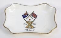 ‘For The Ashes’. Aynsley Pottery oblong pin tray printed in colour with the flags of Australia and England to centre and beneath crossed bats, wicket and ball with title. circa 1930. The pin tray measures 4”x3.25”. Aynsley Pottery stamp to base. Two small