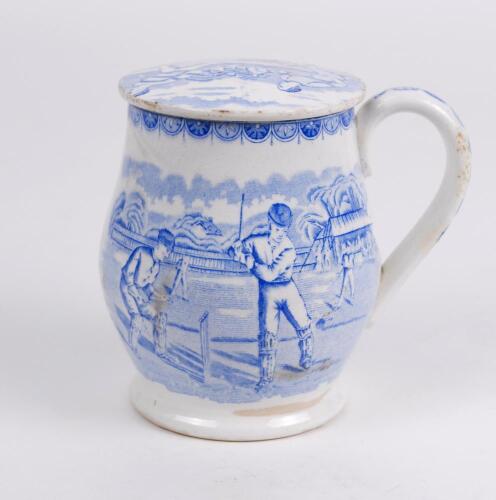 Staffordshire shaving mug. Victorian Staffordshire shaving mug and ceramic cover (lid) with strap handle, transfer printed in blue, with a cricket scene of batsman, wicket-keeper and two fielders with pavilion and trees to background. To verso, a football