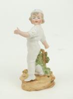 Child cricketer. Small continental figure of a child cricketer, wearing white cap, with ball in hand and in bowling pose standing on naturalistic base with wicket behind. Number 981 to back of figure on base. 5” tall. Not often seen. G