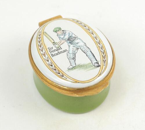 Sir Donald Bradman. Modern enamelled oval pillbox hand decorated with a portrait of Bradman standing full length in batting pose. Set of stumps decoration to inside lid. Produced by Crummles of Poole, Dorset. VG