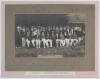 M.C.C. England tour of Australia 1924-25. England v Tasmania 1925. Official photograph of the two teams and officials, seated and standing in rows, wearing cricket attire, blazers, caps and hats, standing in front of the side of the pavilion and a large t