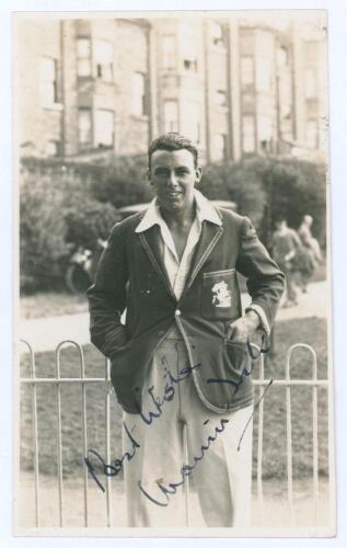 Maurice William Tate. Sussex & England 1912-1937. Original mono real photograph postcard of Tate standing three quarter length in front of railings at Scarborough, wearing cricket attire and England blazer. Nicely signed in ink to the photograph by Tate. 