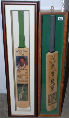&lsquo;West Indies Cricketing Knights&rsquo;. Two signed cricket bats, both mounted in glazed display cases. The first a full size bat with images of Sir Garry Sobers, Clyde Walcott and Sir Vivian Richards, signed by all three, some fading to the signature of Sobers.