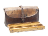 A Wheatley pigskin coarse fisherman's compendium wallet, the rectangular case fitted central removeable treen float and line winder, end pouch pockets and parchment cast leaves withy felt damper, wrap around strap, circa 1900