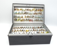 A black stove enamelled rectangular salmon fly reservoir, fitted five lift-out trays each with bars of nickel silver spring fly clips and holding a good selection of approximately 380 salmon flies, including low water patterns and five Farlow examples in 