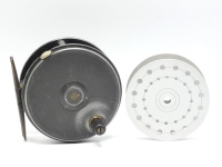 A Dingley built 4" alloy salmon fly reel and (later) spare spool, composition handle, brass foot, milled rim tension screw and bar spring check mechanism, drum with two bands of large and small perforations and milled nickel silver locking screw, interior